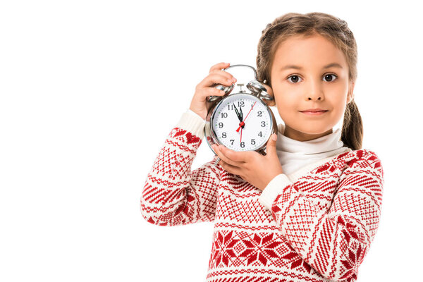 adorable little child holding alarm clock and looking at camera isolated on white
