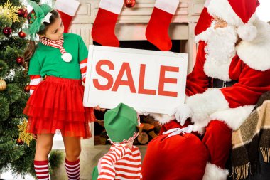 Çocuklar elf kostümleri ve satışı büyük başlığı, holding santa Noel alışveriş
