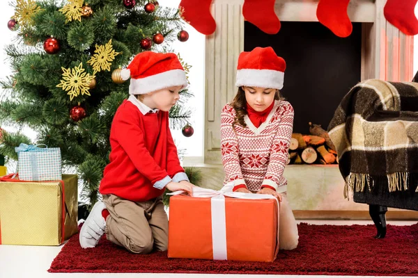 Little Kids Opening Red Christmas Gift While Sitting Floor — Stock Photo, Image