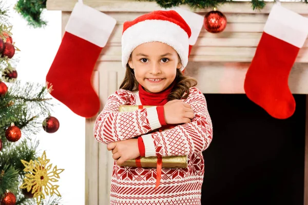 Lächelndes Kleines Kind Mit Weihnachtsgeschenk Und Blick Die Kamera — kostenloses Stockfoto