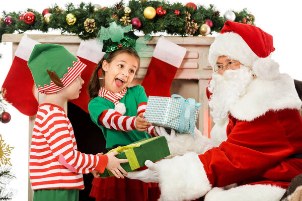 kids taking christmas gifts from santa claus isolated on white