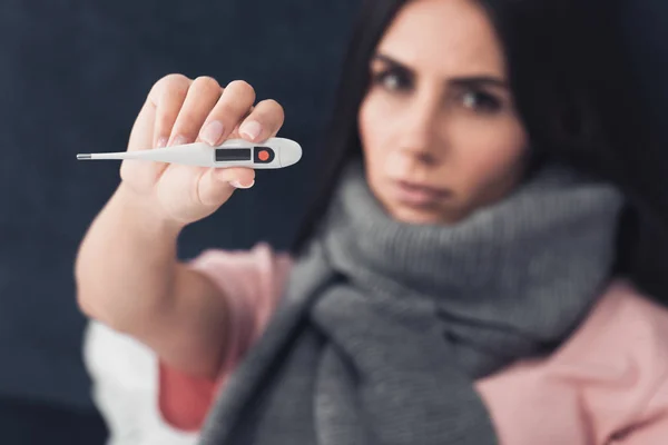 Sick Young Woman Showing Electronic Thermometer While Sitting Bed — Free Stock Photo