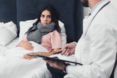 Genç kadının Pano tutan Doktor süre yatakta yalan kırpılmış atış