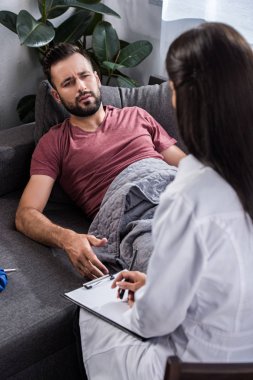 kadın doktor acı çeken kadının oturmak pano ile Dikiz