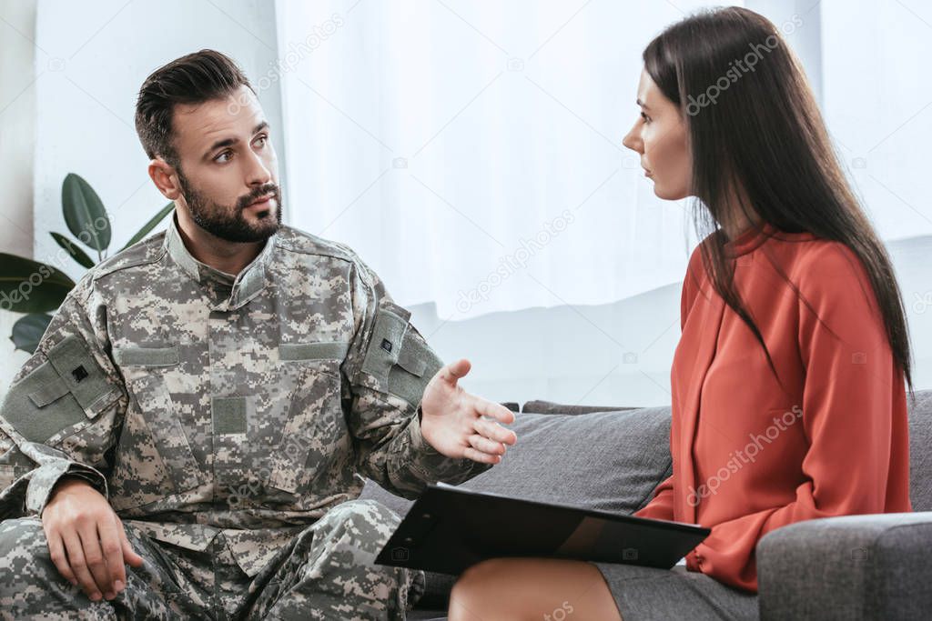 soldier in uniform with ptsd talking to psychiatrist at therapy session