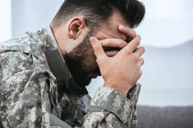 depresif ordu adam başını tutan travma sonrası stres bozukluğu olan askeri üniformalı yan görünüm