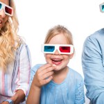 Family with 3d glasses eating popcorn isolated on white