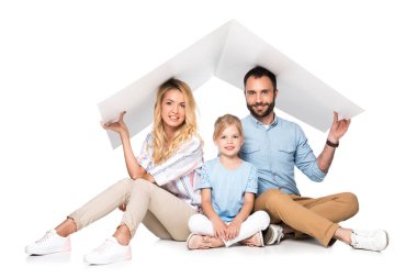 parents with daughter holding white roof over heads isolated on white, family insurance concept clipart
