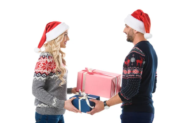 Couple Christmas Sweaters Santa Hats Gifting Presents Isolated White — Free Stock Photo
