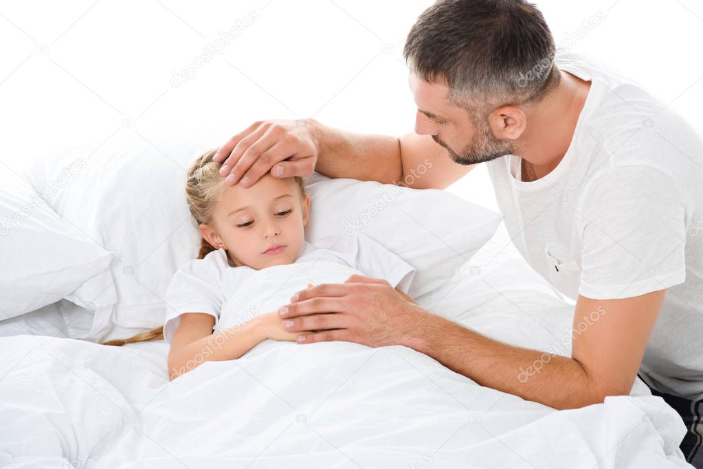 parent touching forehead of sick daughter with temperature lying in bed, isolated on white
