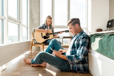 odaklı adam kız akustik gitar evde oynarken sırasında dijital tablet kullanma