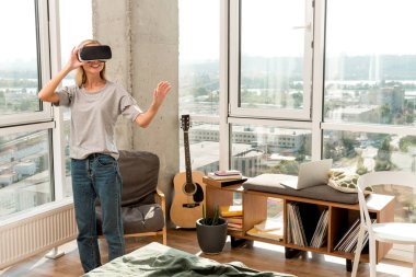 vr kulaklık evde el hareketi içinde neşeli genç kadın