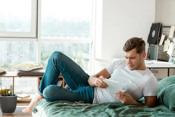 Άνθρωπος Χρησιμοποιώντας Tablet Ενώ Ξαπλωμένος Στο Κρεβάτι Στο Σπίτι — Φωτογραφία Αρχείου