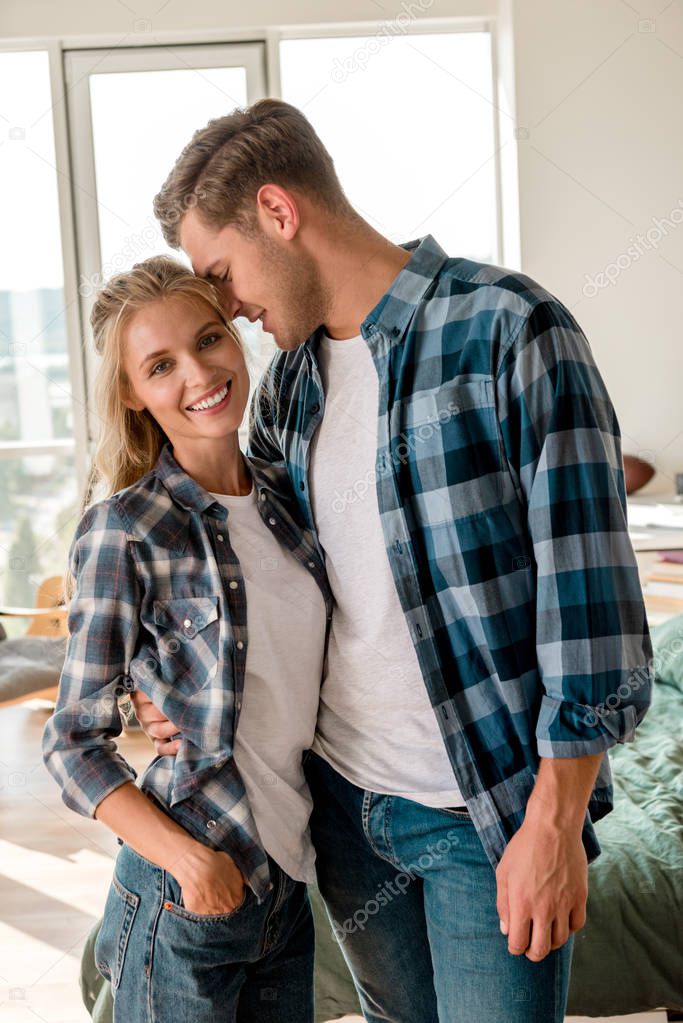 portrait of happy loving couple hugging at home