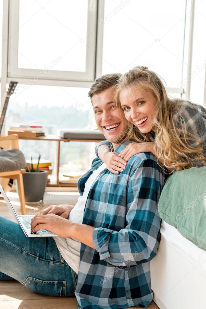 happy couple with digital laptop at home