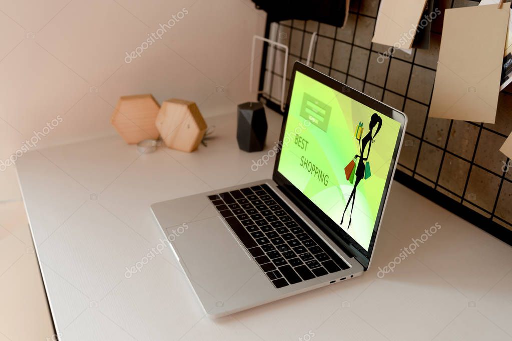 Close up view of digital laptop with best shopping logo on screen on tabletop at home