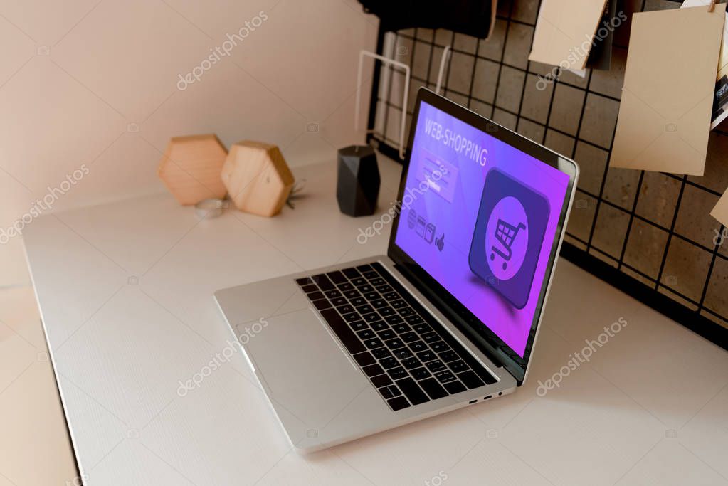 Close up view of digital laptop with web shopping lettering on tabletop at home