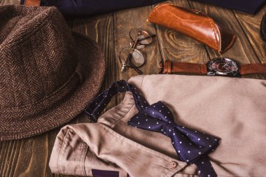 close up view of arrangement of masculine shirt and accessroies on wooden tabletop clipart