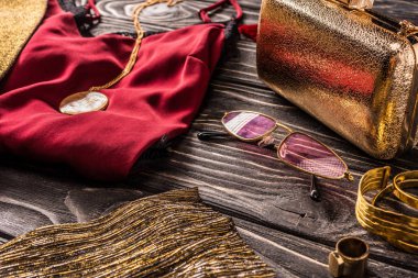 altın ve kırmızı moda kadınsı aksesuarları ve giyim ahşap yüzeyde oluşan görünümünü kapat