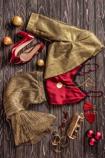 flat lay with arrangement of fashionable feminine clothing, shoes and accessories on wooden surface
