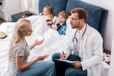 yüksek açı görünümü arka plan üzerinde yatakta yatan hasta çocuk iken anne ve çocuk doktoru