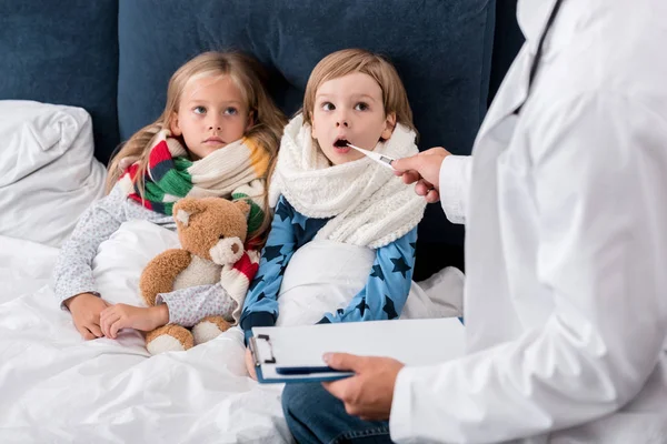 Cropped Shot Pediatrician Clipboard Examining Temperature Kids Lying Bed — Stock Photo, Image