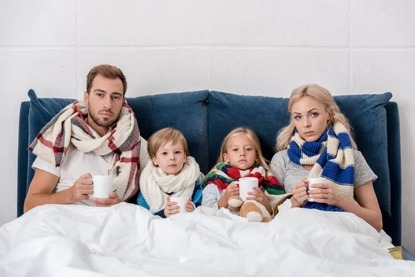 Kranke Junge Familie Mit Tassen Heißgetränk Bett Sitzend Und Die — Stockfoto