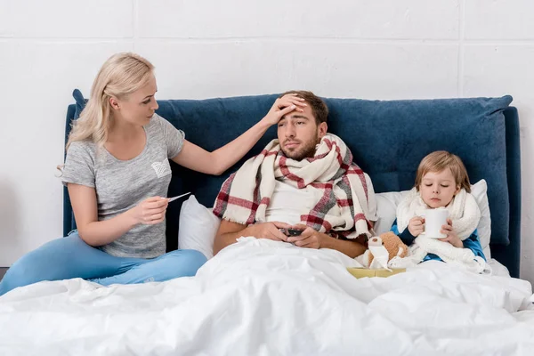 Donna Controllare Temperatura Del Marito Malato Figlio Mentre Trovano Letto — Foto Stock