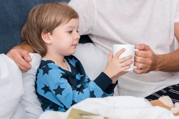 Cropped Shot Father Giving Cup Hot Drink His Son Bed — Stock Photo, Image