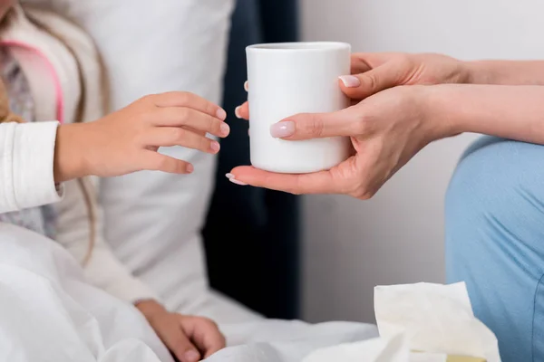 Recortado Disparo Madre Dando Taza Caliente Hija Enferma Cama — Foto de Stock