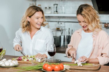 mutlu olgun anne ve yetişkin kızı mutfak at birlikte salata çatalı
