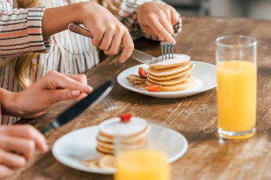Anne ve kızı çilek ile pancakes yemek atış kırpılmış