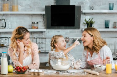 Hamur hazırlama ve annem ve anneannem evde oynarken küçük çocuk gülümseyen