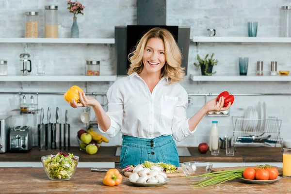 Biber Salatası Mutfak Yaparken Kameraya Bakarak Ile Güzel Yetişkin Kadın — Stok fotoğraf