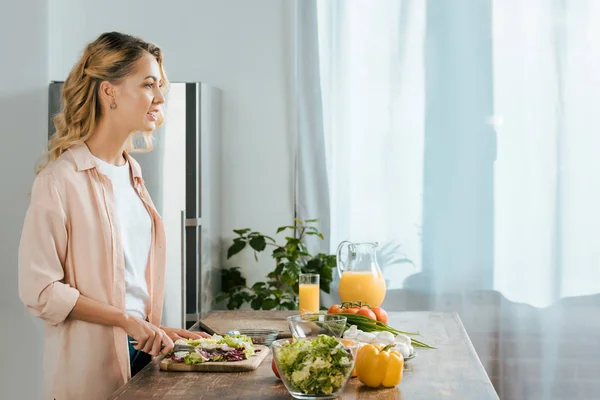 Vista Lateral Atraente Jovem Mulher Cortando Alface Para Salada Cozinha — Fotografia de Stock