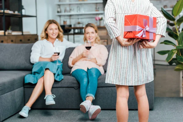 Cropped Shot Child Hiding Present Back While Mother Grandmother Sitting — Free Stock Photo