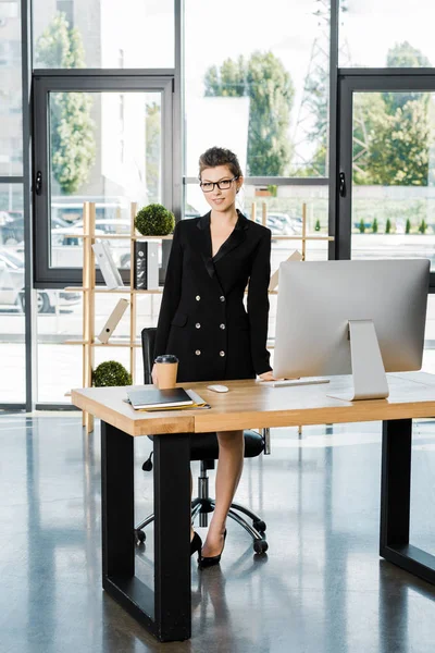 Ελκυστικός Επιχειρηματίας Στέκεται Κοντά Πίνακας Στο Γραφείο Και Βλέπουν Φωτογραφικών — Δωρεάν Φωτογραφία