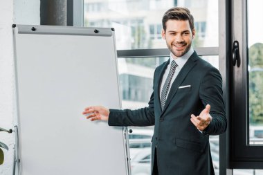 takım elbise ayakta Office boş beyaz tahta, neşeli işadamı portresi