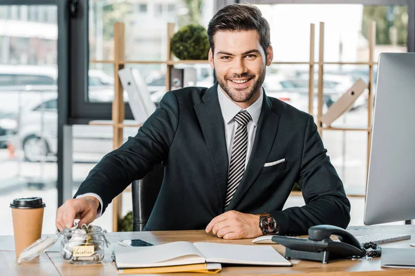 Retrato Homem Negócios Sorrindo Colocando Dinheiro Frasco Vidro Com Inscrição — Fotografia de Stock