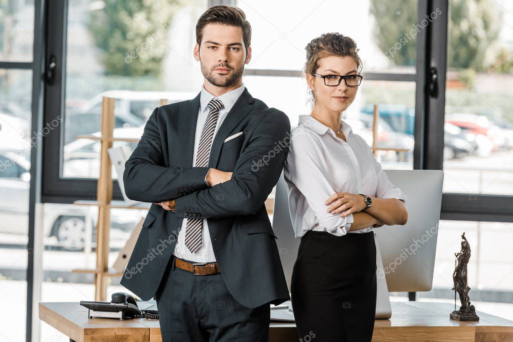 portrait of confident business people in formal wear with arms crossed in office