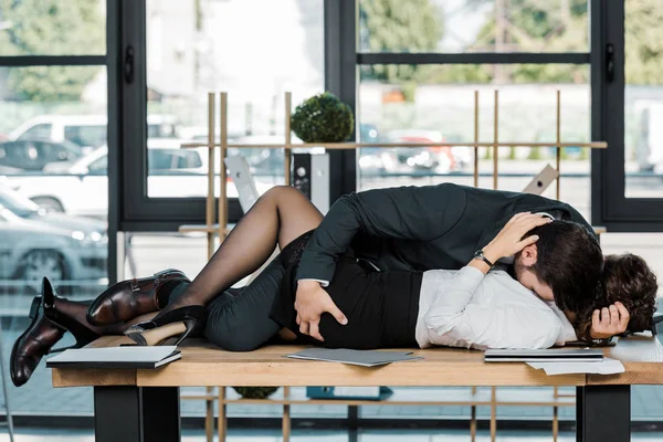 有激情的商人和女商人躺在办公室的桌子上 — 图库照片