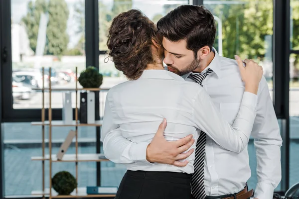 热情的商务同事在正式的穿着拥抱在办公室 — 图库照片