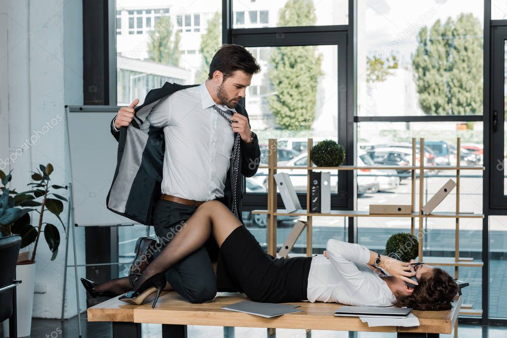 passionate businessman and businesswoman on table in office