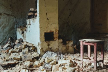 terk edilmiş binada kırık tuğla duvar ve toz ile ahşap sandalye