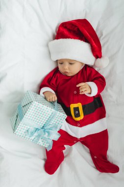 küçük bebek beşik Noel hediye ile yalan Noel Baba kıyafetli üstten görünüm