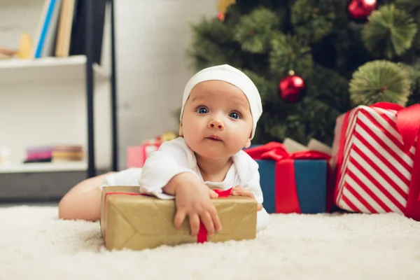 愛らしい赤ちゃんのクリスマス プレゼントを床に横たわって — ストック写真