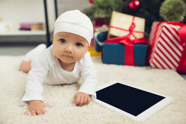 可爱的小婴儿与平板躺在地板上的圣诞礼物模糊背景 — 图库照片