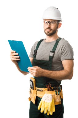 handsome electrician with tool belt holding clipboard and looking at camera isolated on white clipart
