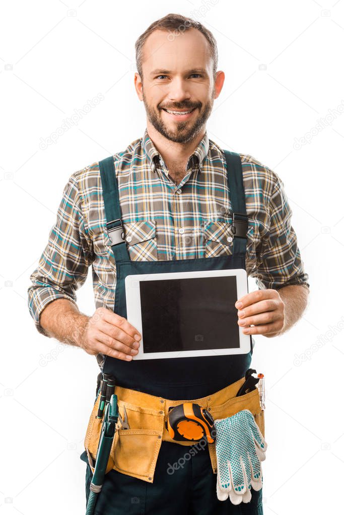 handsome smiling plumber showing tablet with blank screen isolated on white