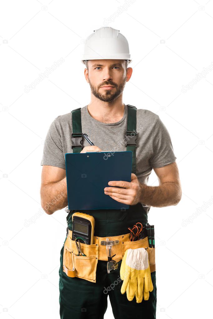handsome electrician holding clipboard and looking at camera isolated on white